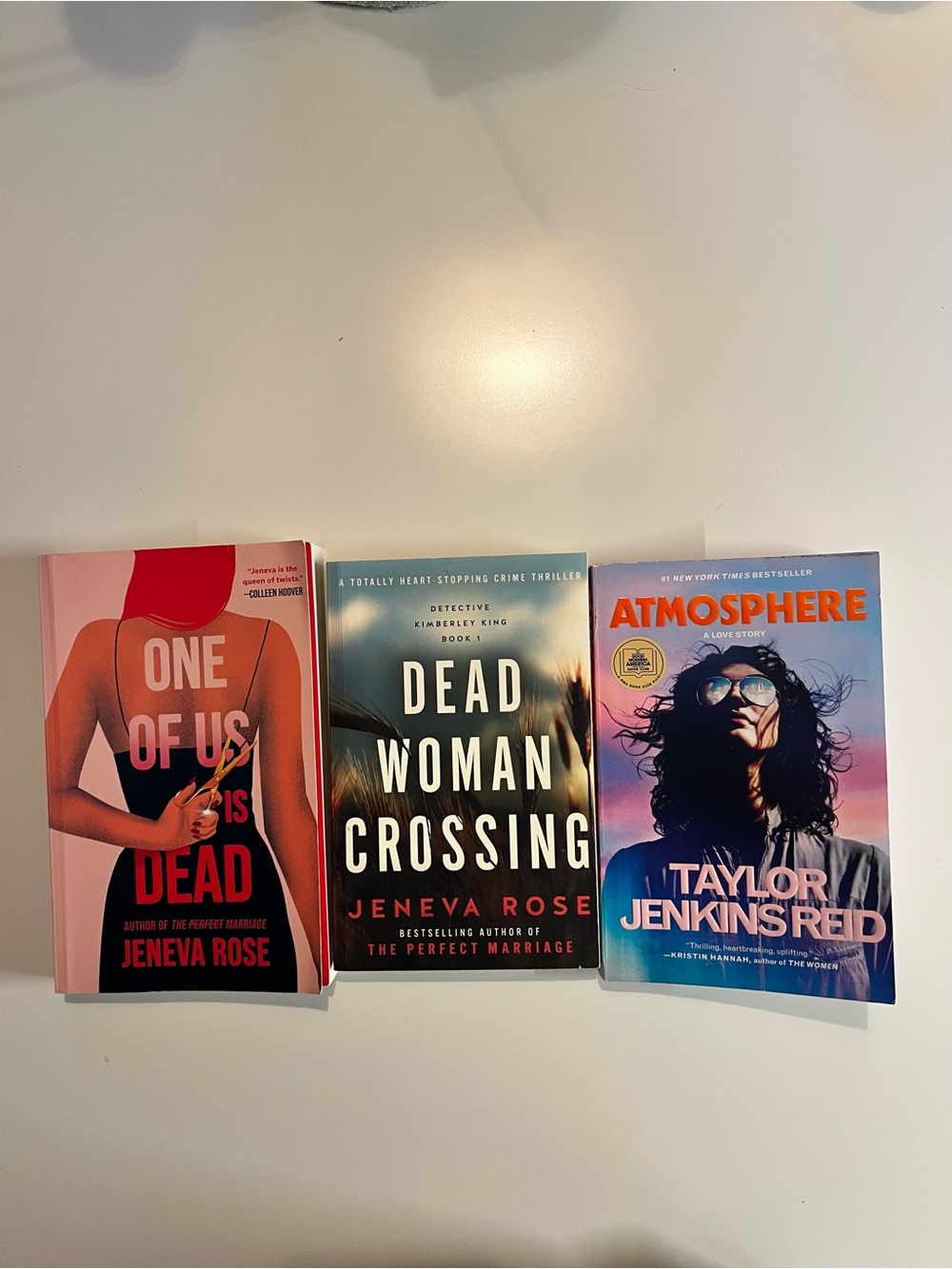 Three used paperback books (one of us is dead, dead woman crossing, atmosphere)